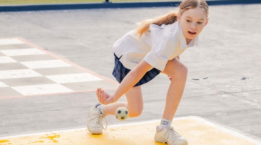 A student enjoying a game of handball, showcasing focus and skill during the match.