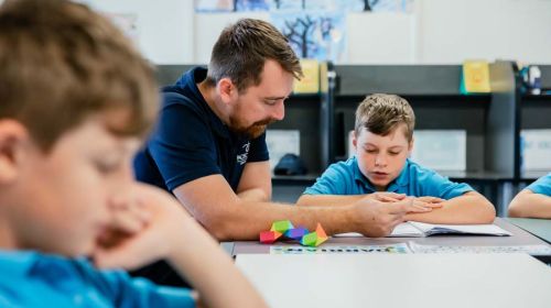 A Youth Support Worker providing assistance to a student with their classwork.